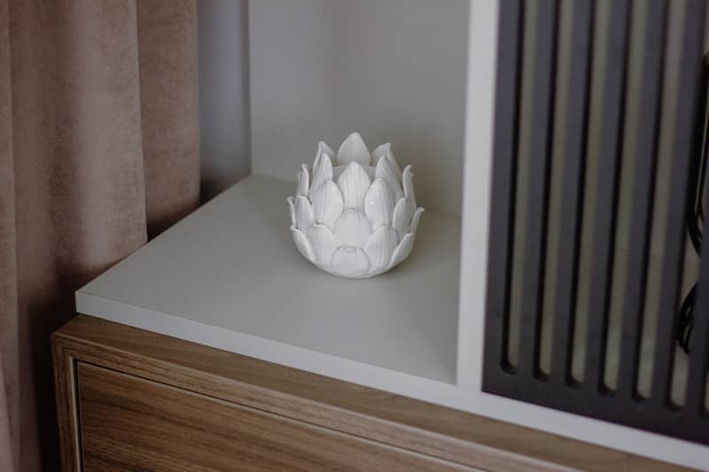 A white vase sitting on top of a wooden dresser