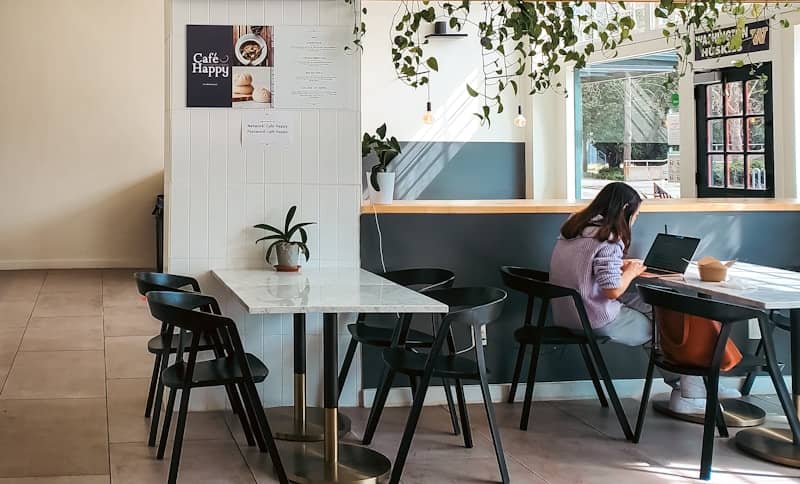 A woman works at a cafe table.