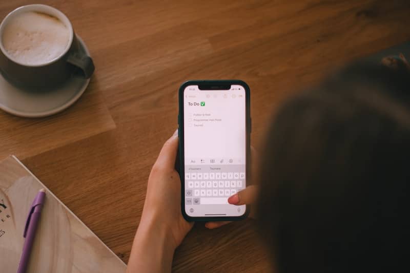 Someone is using a smartphone on a table.
