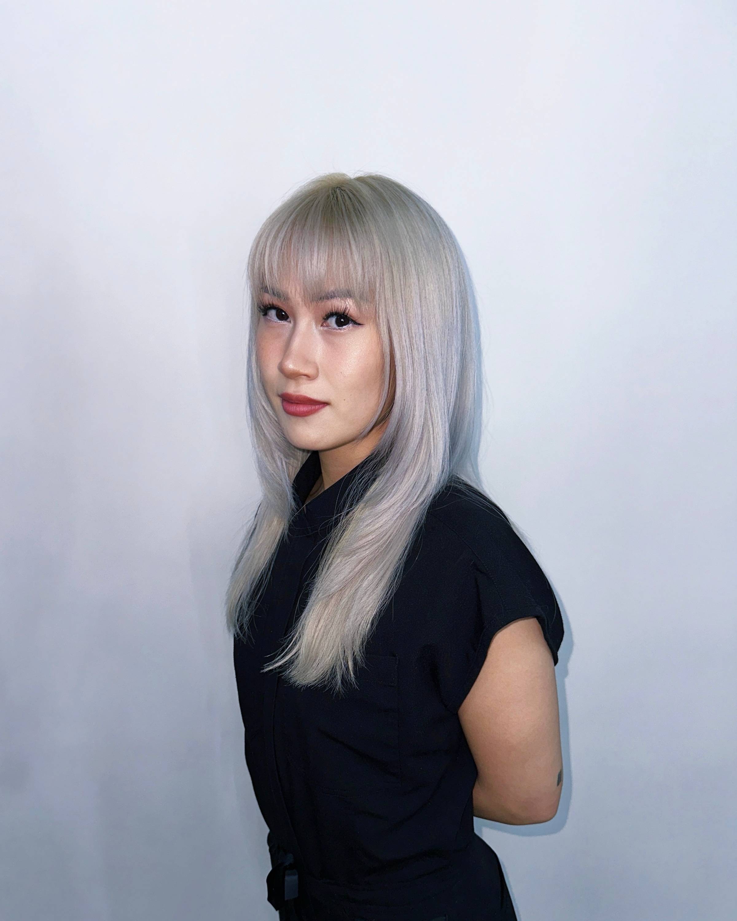 Portrait of a nurse with silver hair wearing a black top, facing the camera.