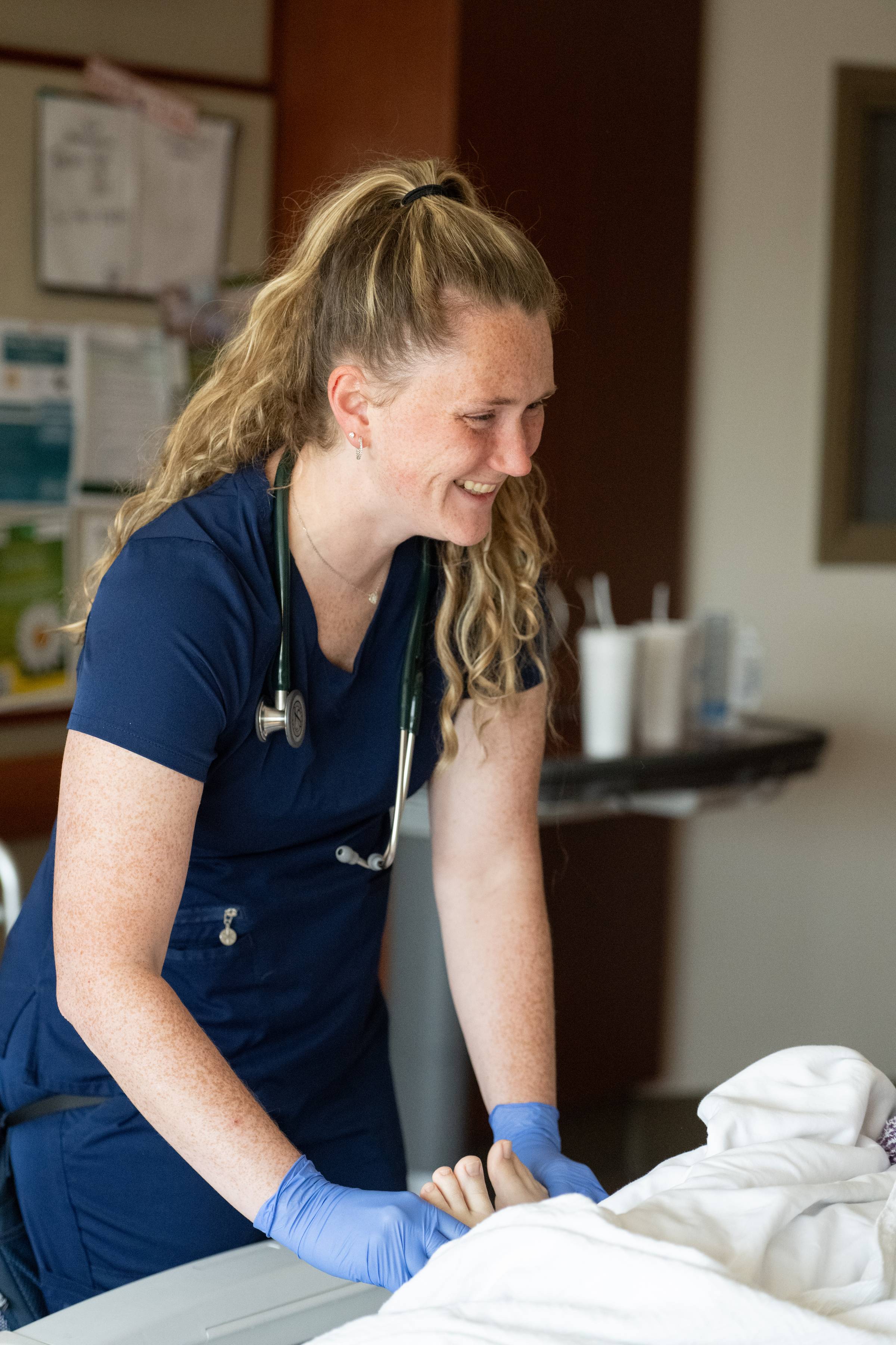 Ashley Engles, RN, BSN, an oncology nurse, smiles while interacting with a patient.