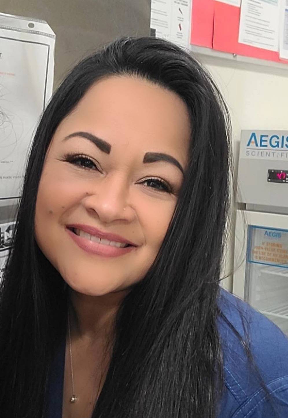 Nurse Sharon Virgen is pictured smiling in her scrubs.