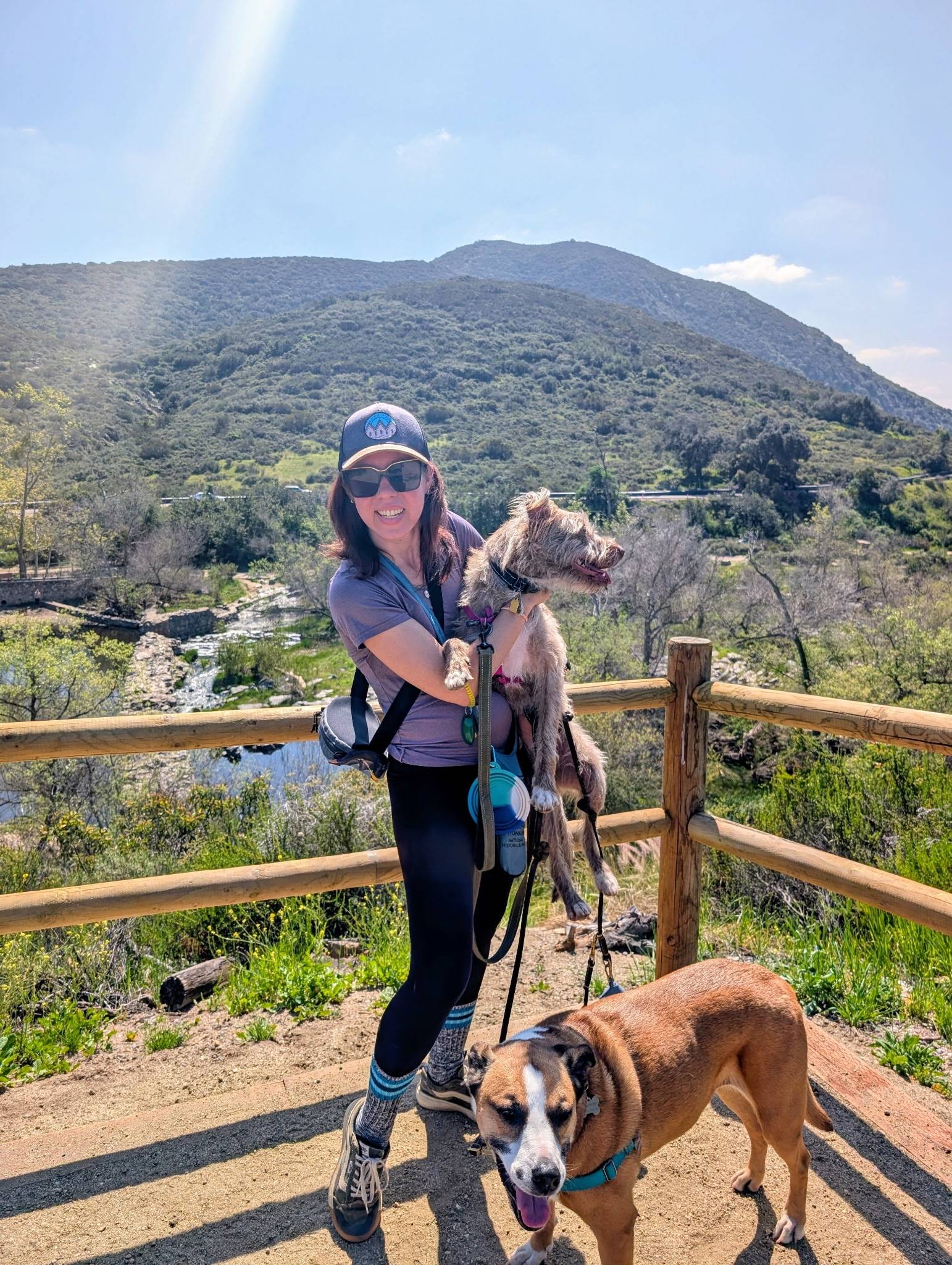 Leila S., RN, BSN, SCRN, smiling while hiking with her dog
