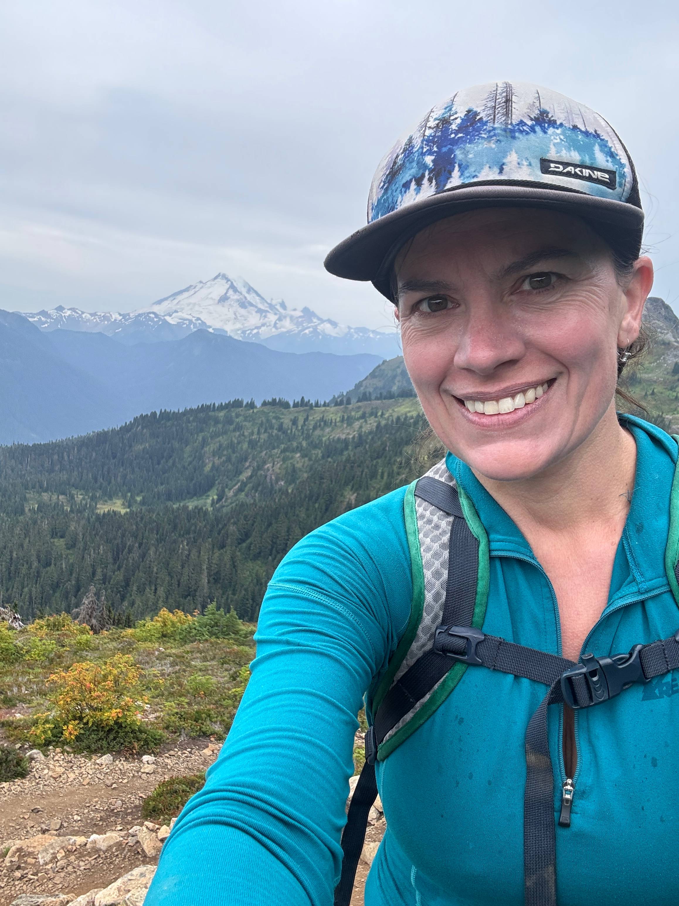 Carly V., MSN, RN, CMSRN, smiling while hiking outdoors in nature