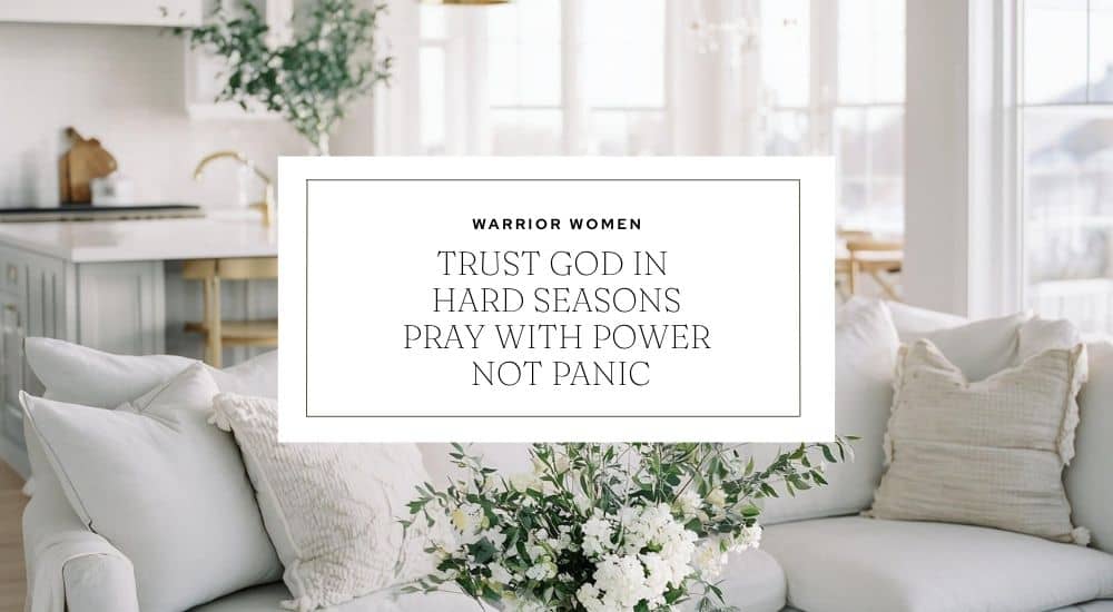 A framed sign resting on a white couch among pillows and flowers, reading: "TRUST GOD IN HARD SEASONS. PRAY WITH POWER NOT PANIC.