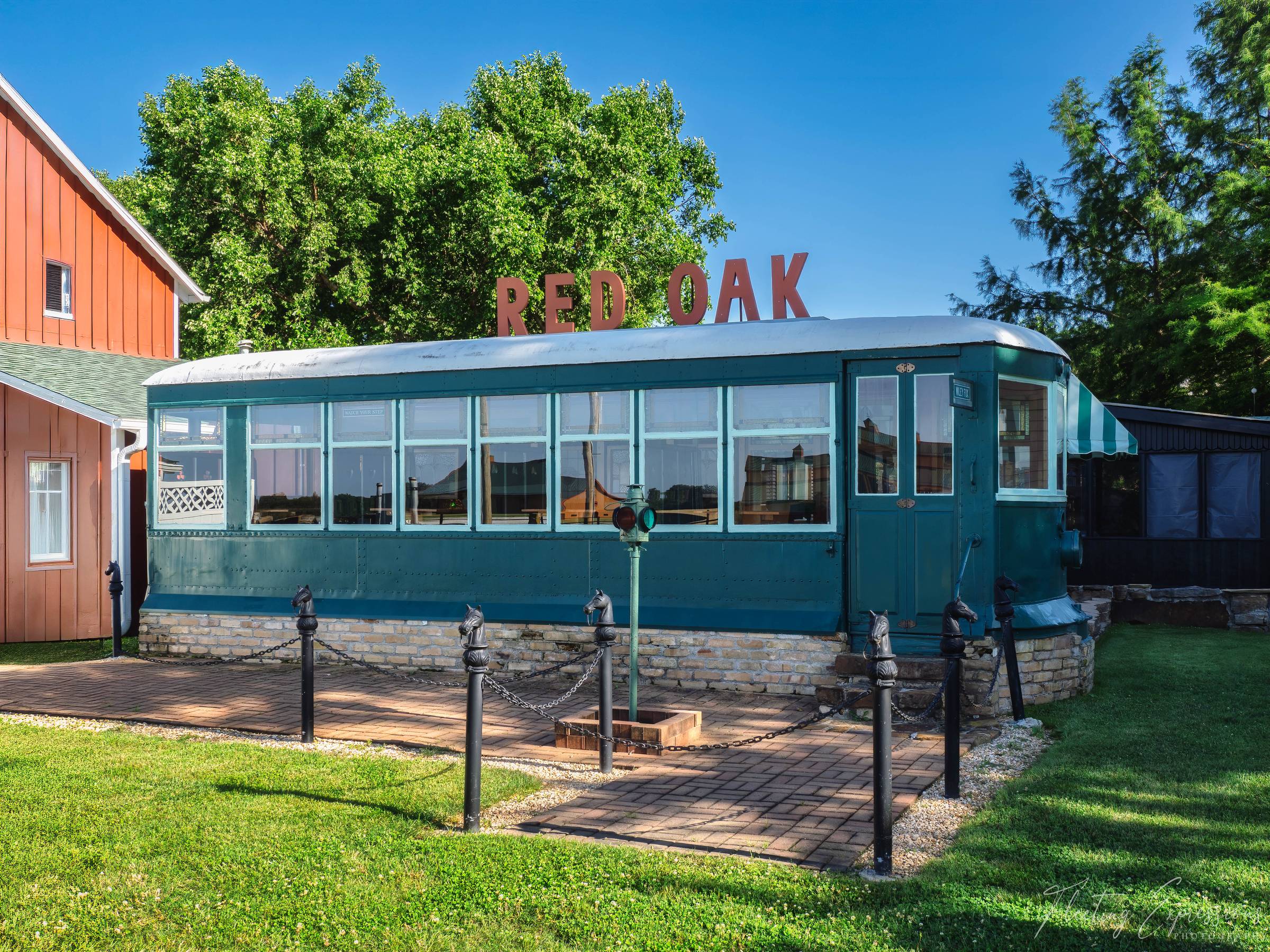 Teal Trolley Car diner at Red Oak II with RED OAK letters on the roof and horse head hitching posts