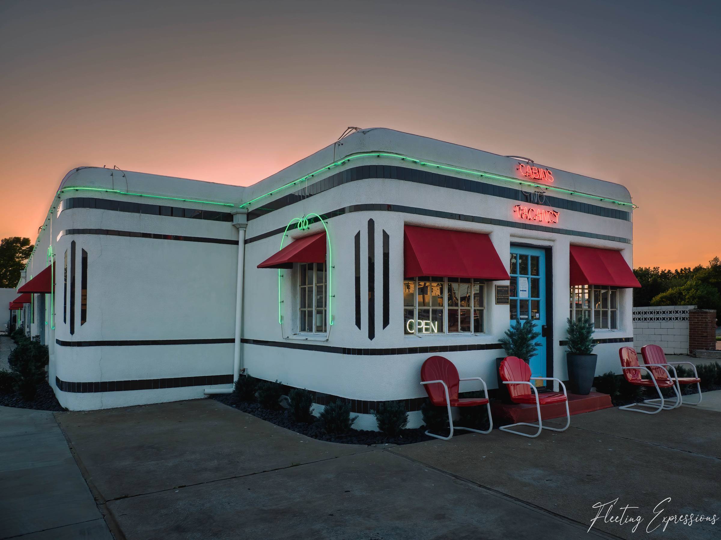 Art deco Boots Court Motel in Carthage, MO at sunset with green neon roofline and red awnings lit