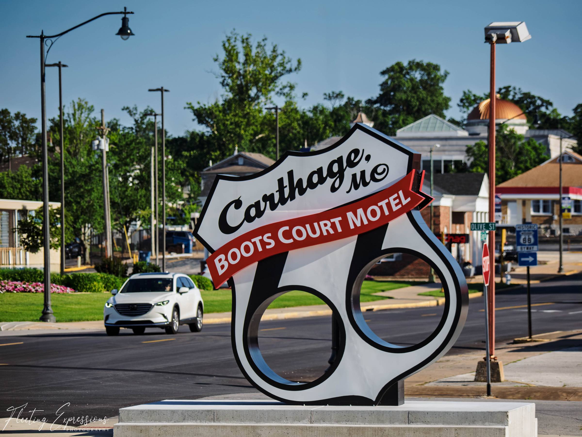 Route 66 shield sign for Boots Court Motel, Carthage, MO with downtown Carthage in the background