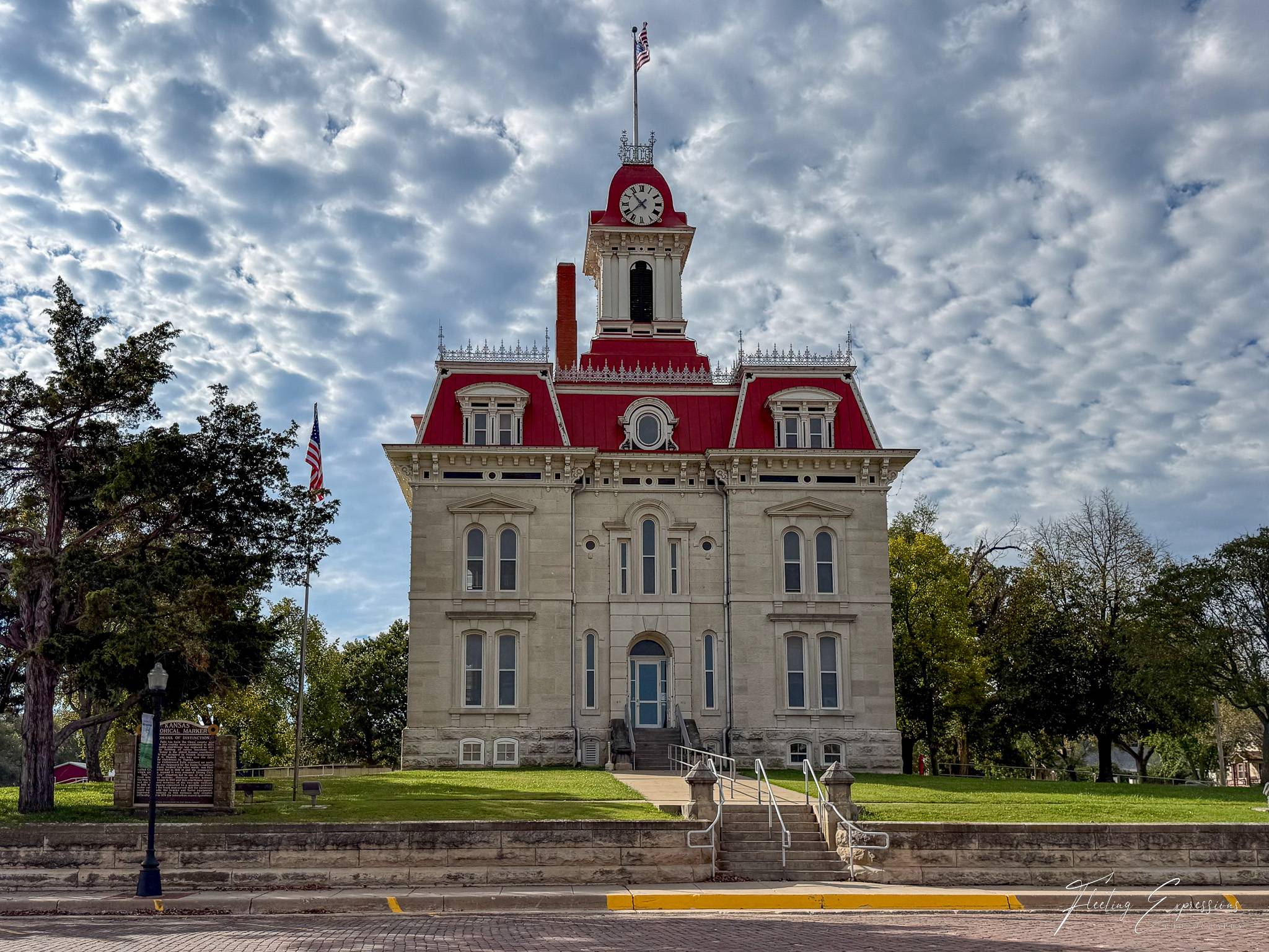 Historic courthouse with red roof and flag on top.