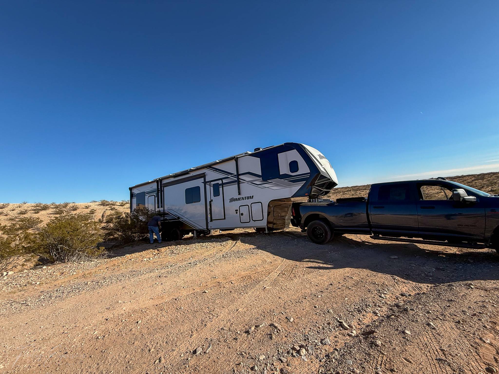 Truck with fifth wheel across a dirt road