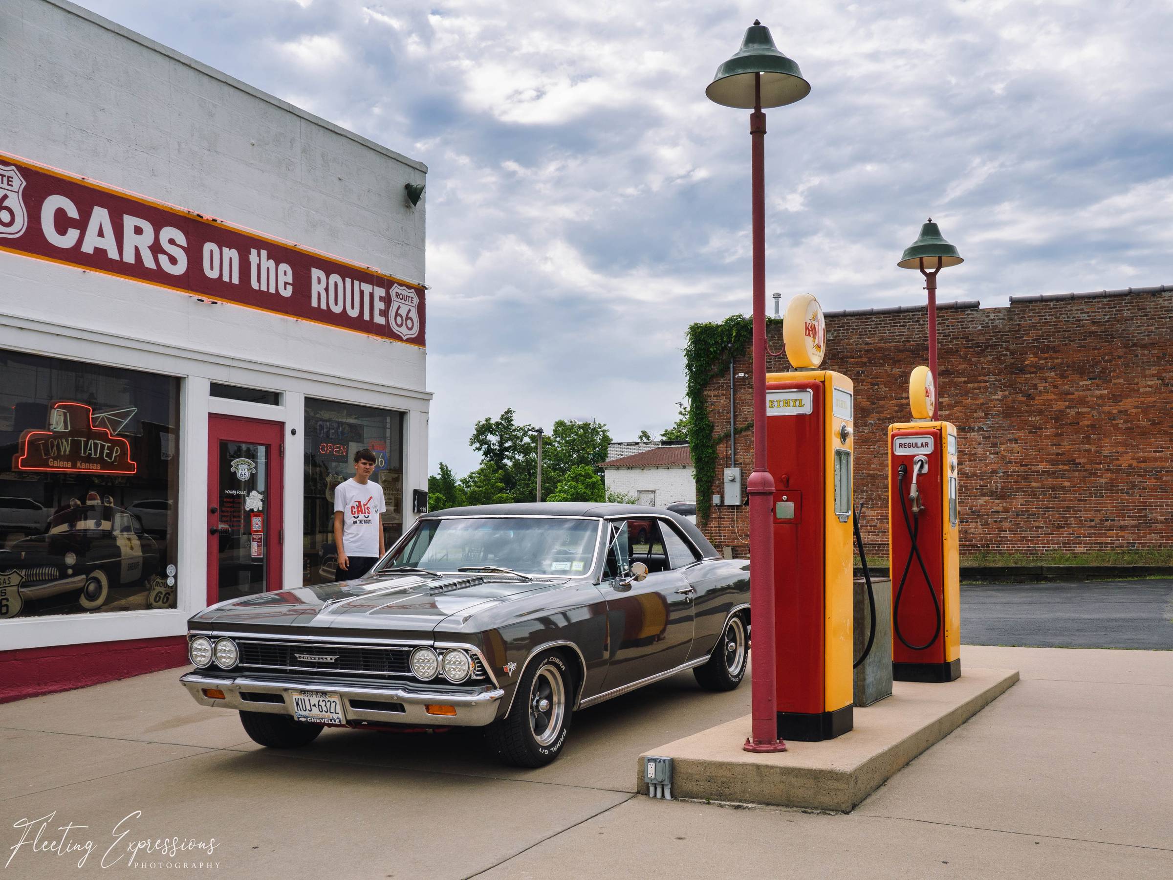 A vintage green Chevelle sits beside two antique gas pumps outside the Cars on the Route building in Galena, Kansas.