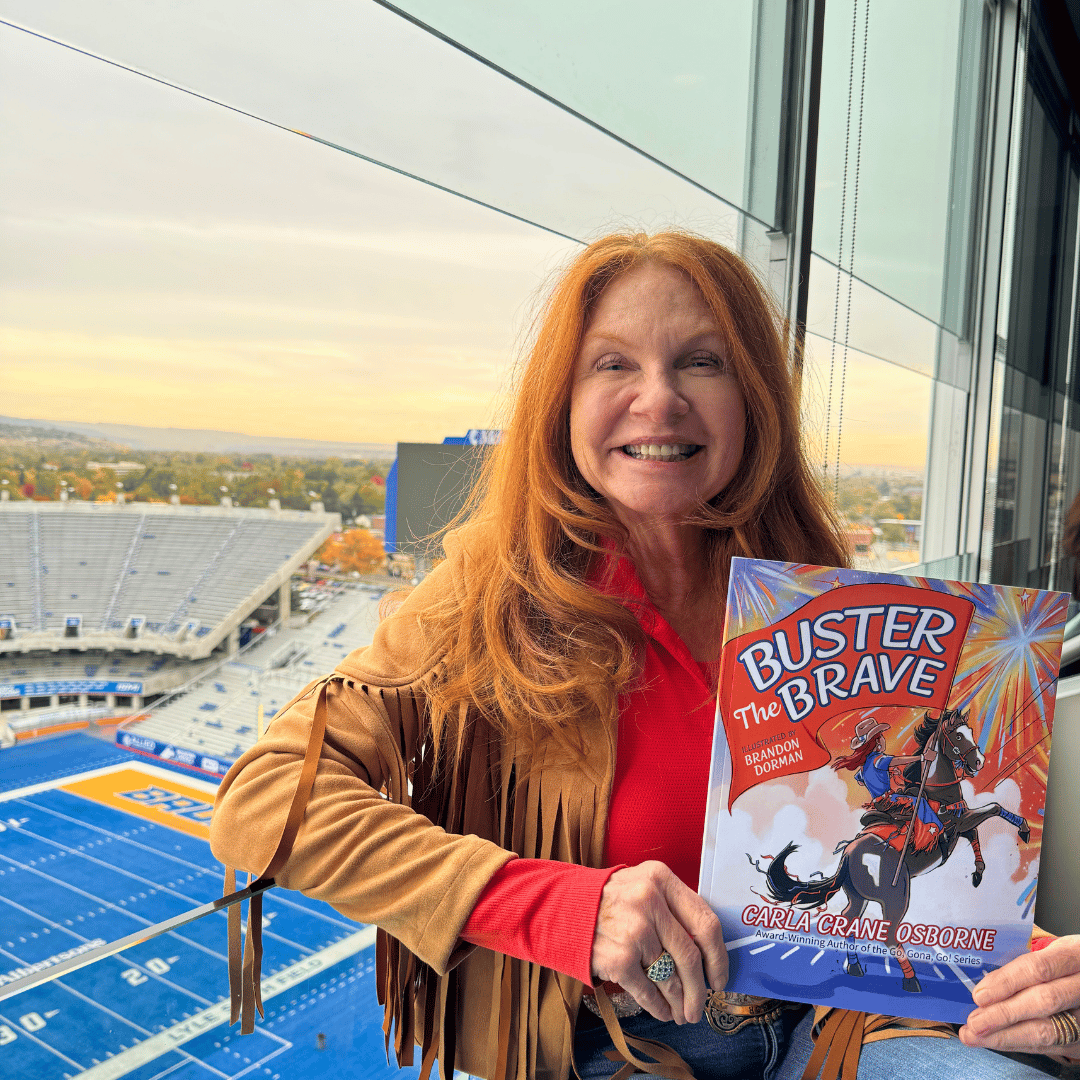 Carla Crane Osborne at the BSU stadium with her book Buster the Brave
