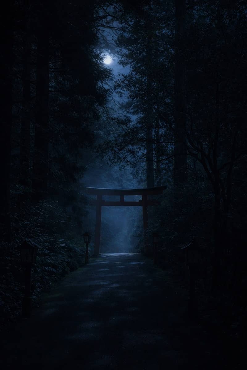 A mystical torii gate in a foggy forest at night