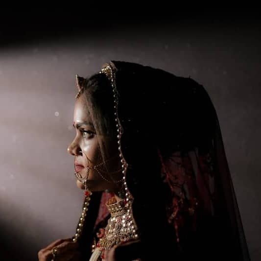 Woman in traditional attire illuminated by spotlight