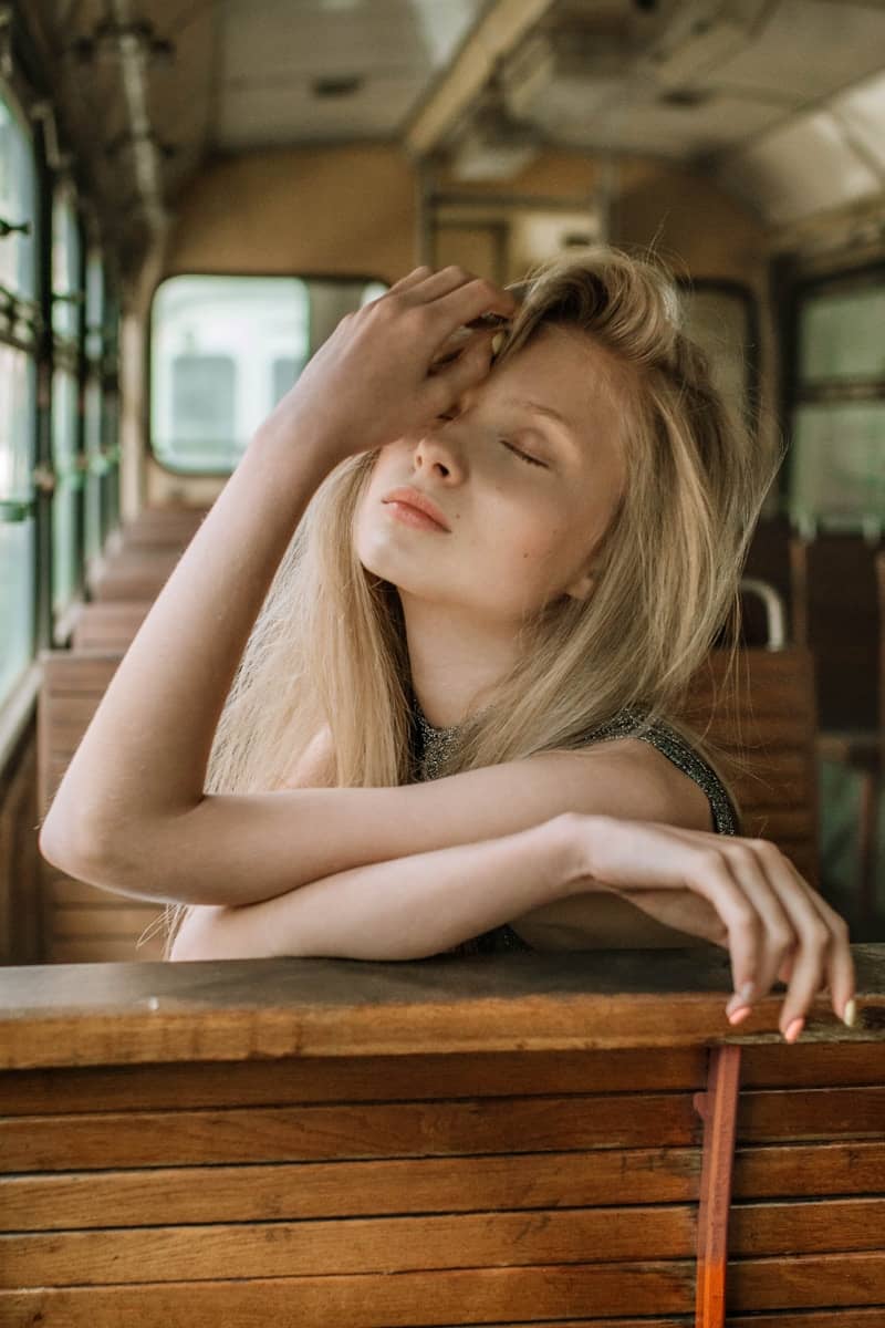 Young blonde woman with closed eyes in an old bus.