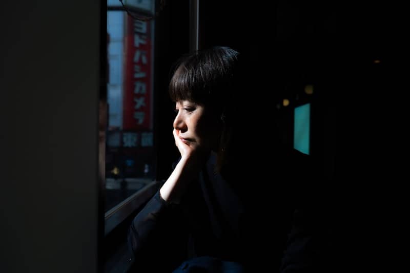 Woman looking out window at night