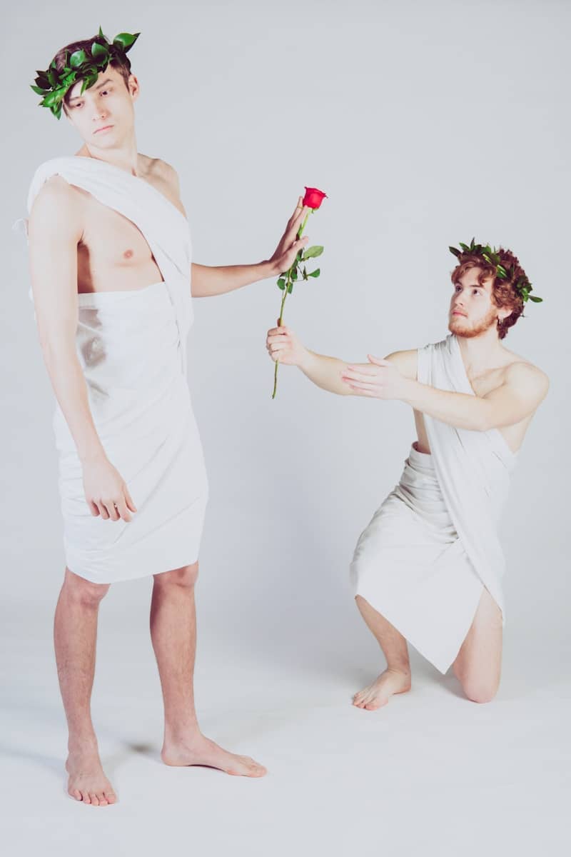 man giving rose to another man