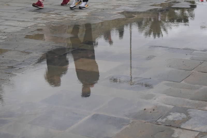 A reflection of a person in a puddle of water
