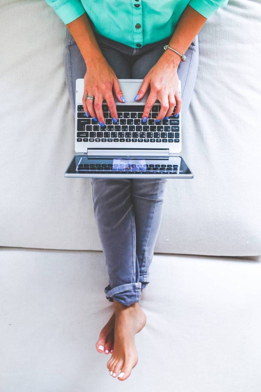 Beige headphones rest on a laptop with an open book.