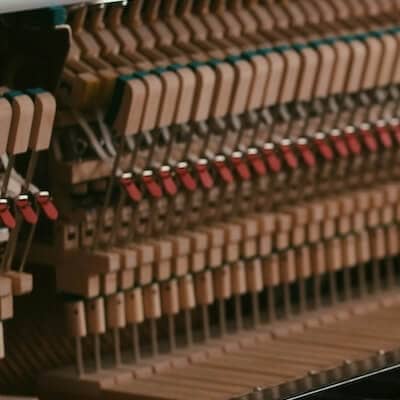The hammers beneath an upright piano cover above the instrument's keys