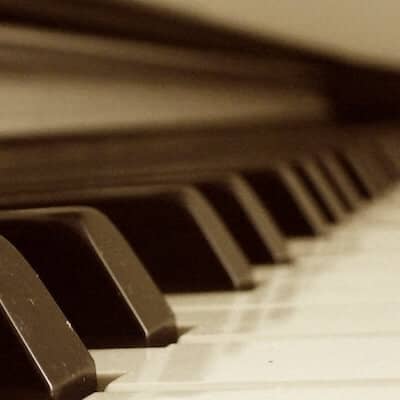 Closeup view from the bottom end of a piano keyboard in sepia tone