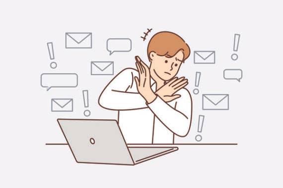 An illustration of a person sitting at a laptop with their arms crossed in an “X” as if refusing or overwhelmed. Message icons, speech bubbles, and exclamation marks float around them, suggesting too many notifications or digital overload.