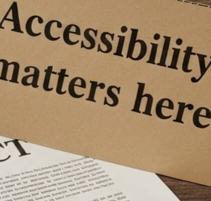 A sign reading “Accessibility matters here” rests on top of a contract, partially obscuring its text.