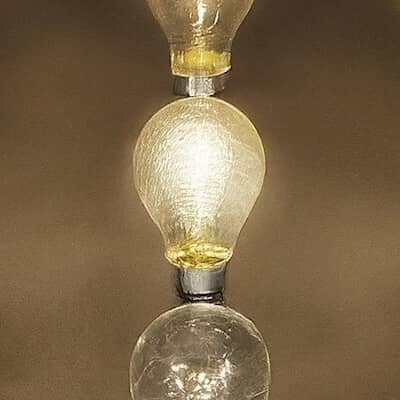 An array of lit lightbulbs arranged in three rows with the bulb in the center shining brightest