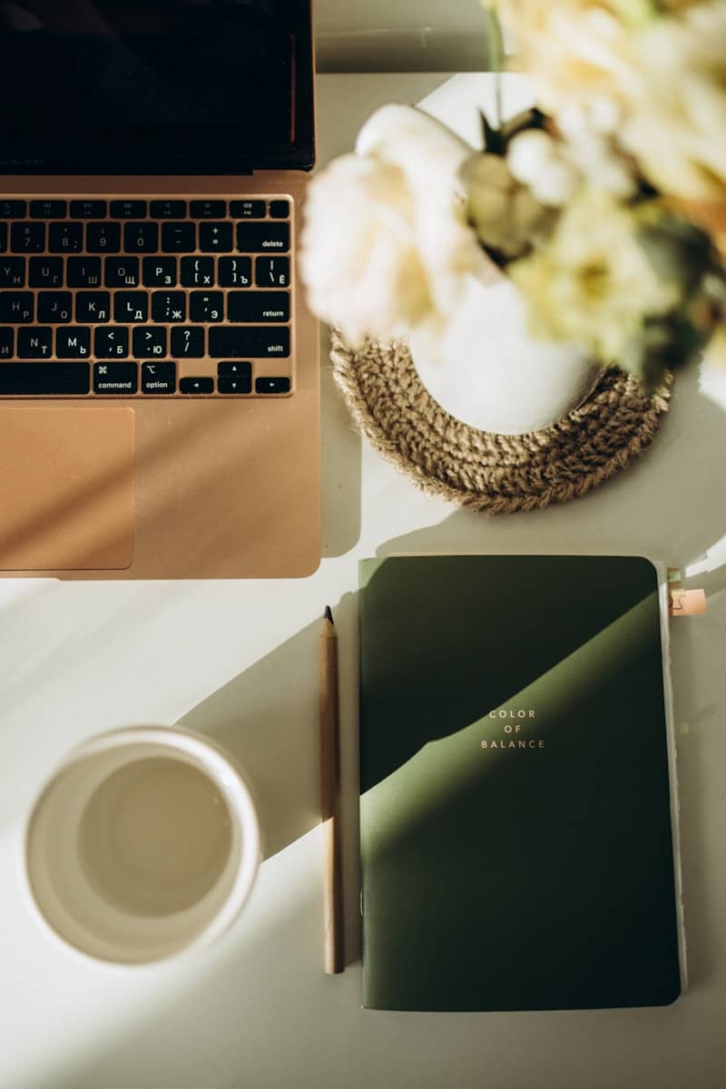 A laptop computer sitting on top of a desk next to a cup of coffee