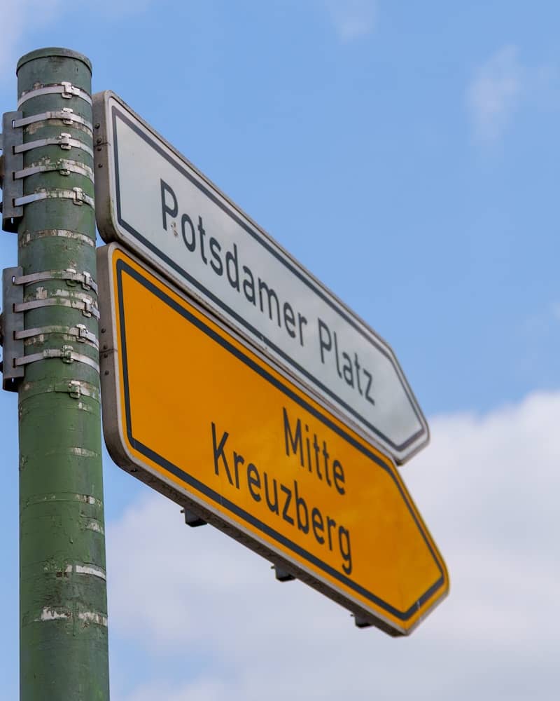 Street signs pointing to potsdamer platz and mitte kreuzberg