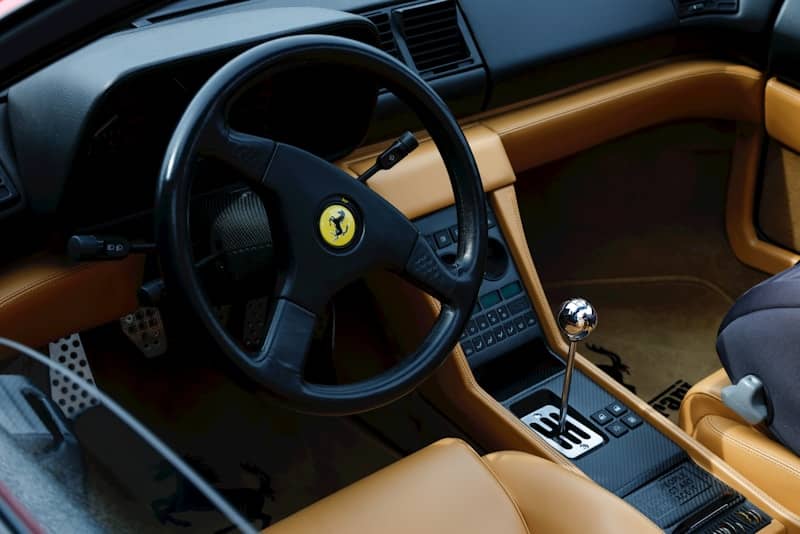Interior of a luxury sports car with tan leather seats.