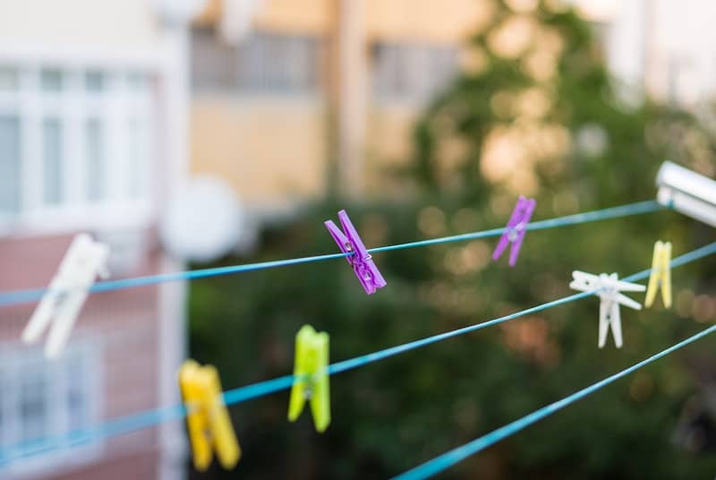Colorful clothespins hanging on a clothesline with a blurred background.