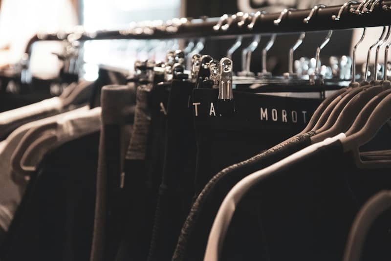 Dark clothing hanging on a store rack