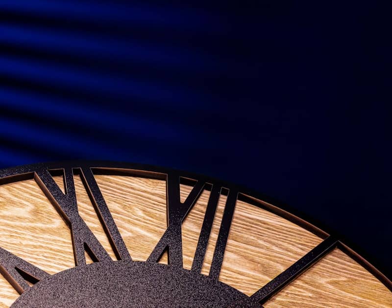 Close-up of a wooden clock face with roman numerals