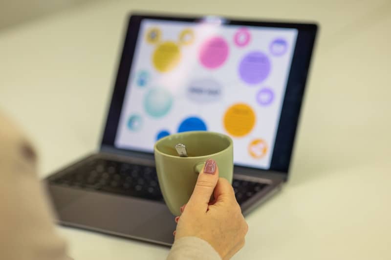 Woman is relaxing with coffee while looking at a laptop.