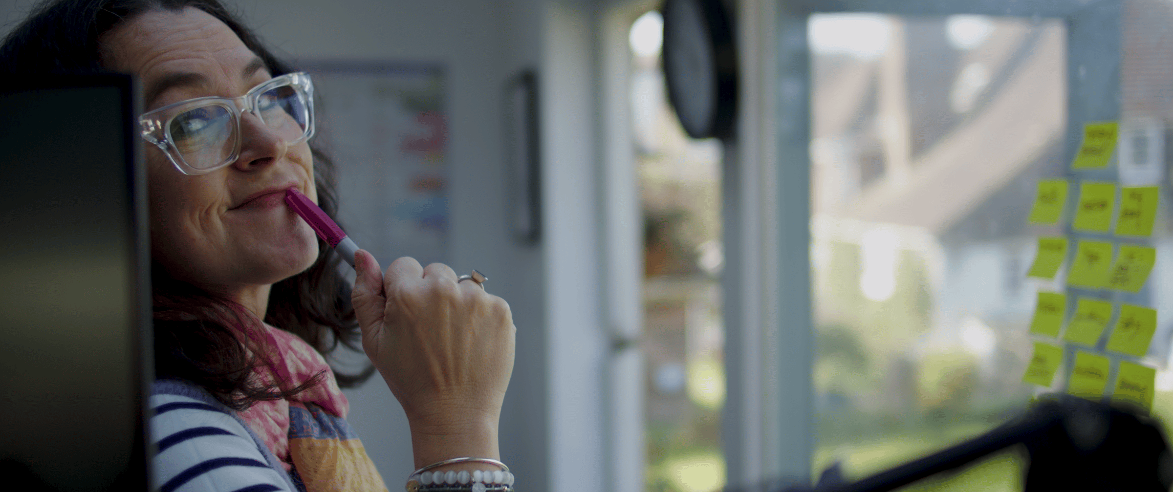women with pen pressed to her lips staring at the camera