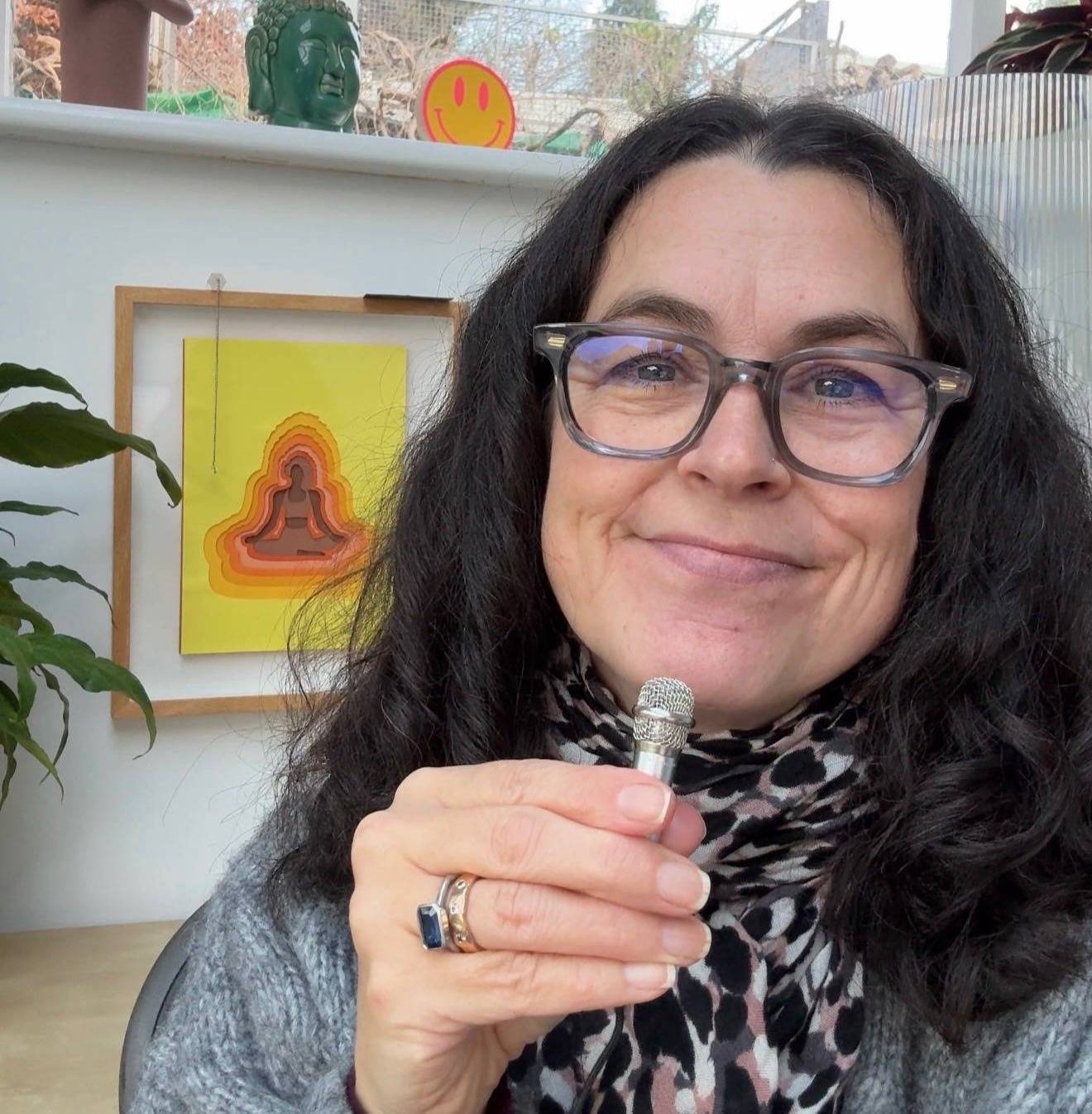 midlife woman smiling with a mini microphone