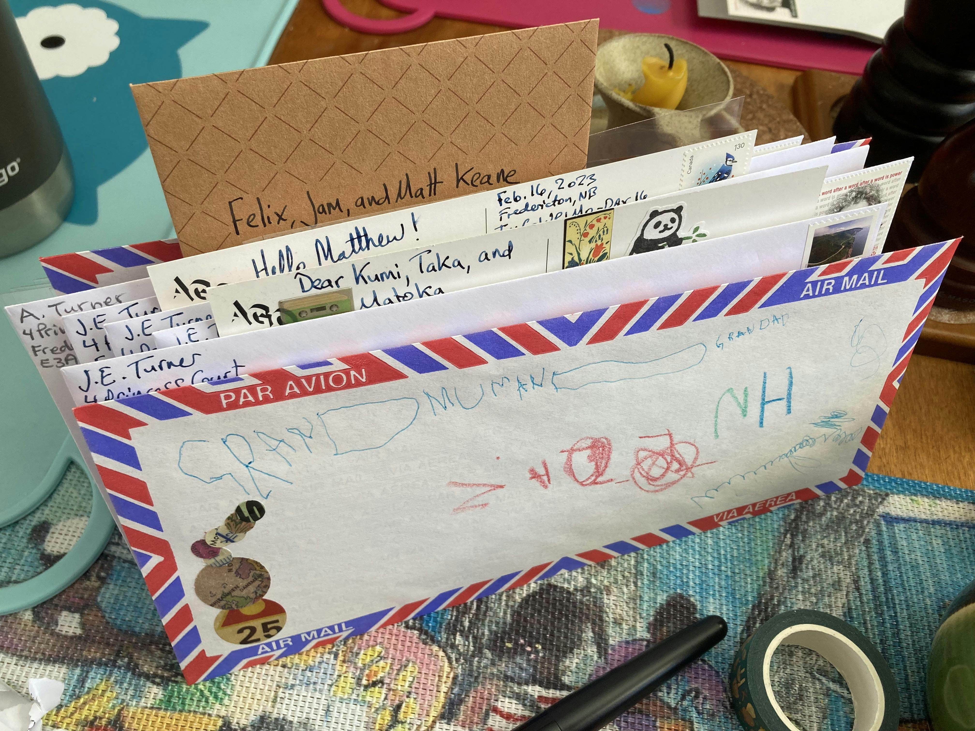 A photo of a stack of letters and postcards waiting to be put in the mail