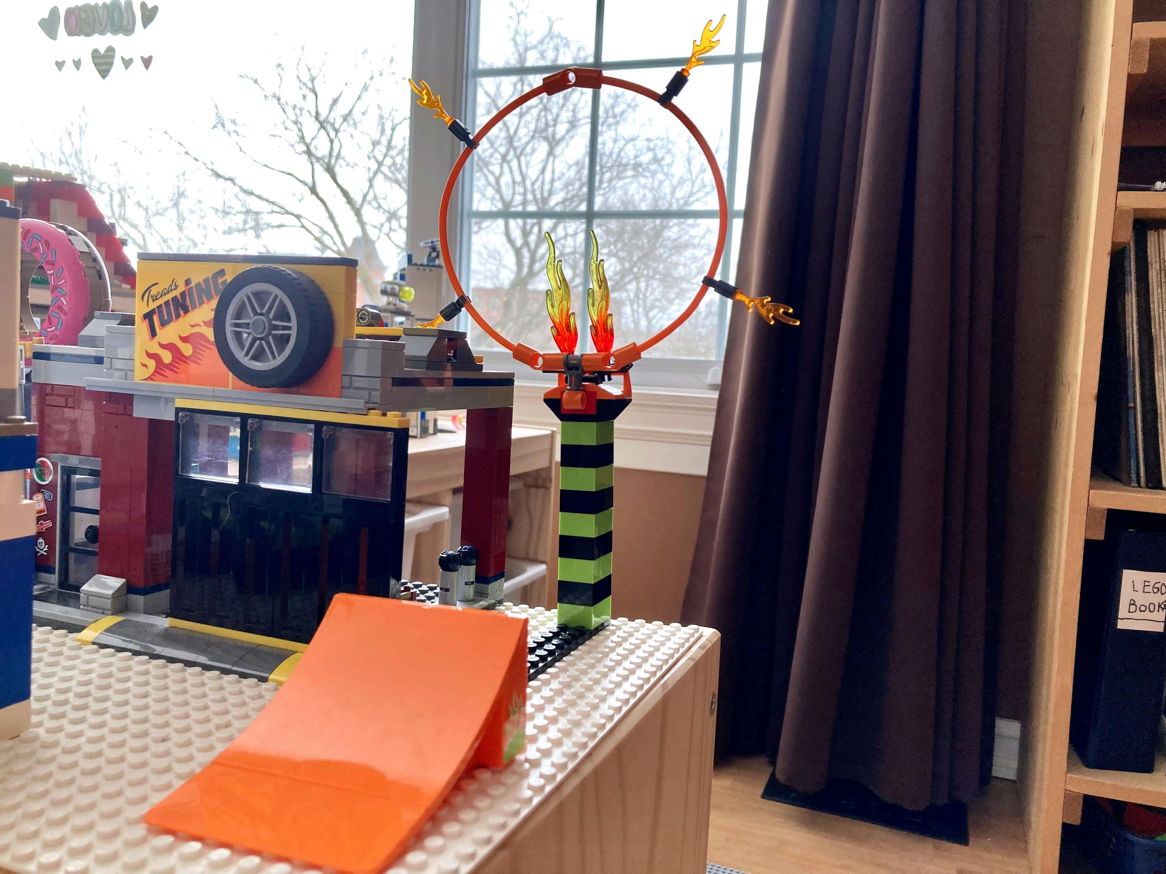 A photo of a LEGO daredevil set with a flaming hoop to jump through and a ramp to launch your bike through the hoop.