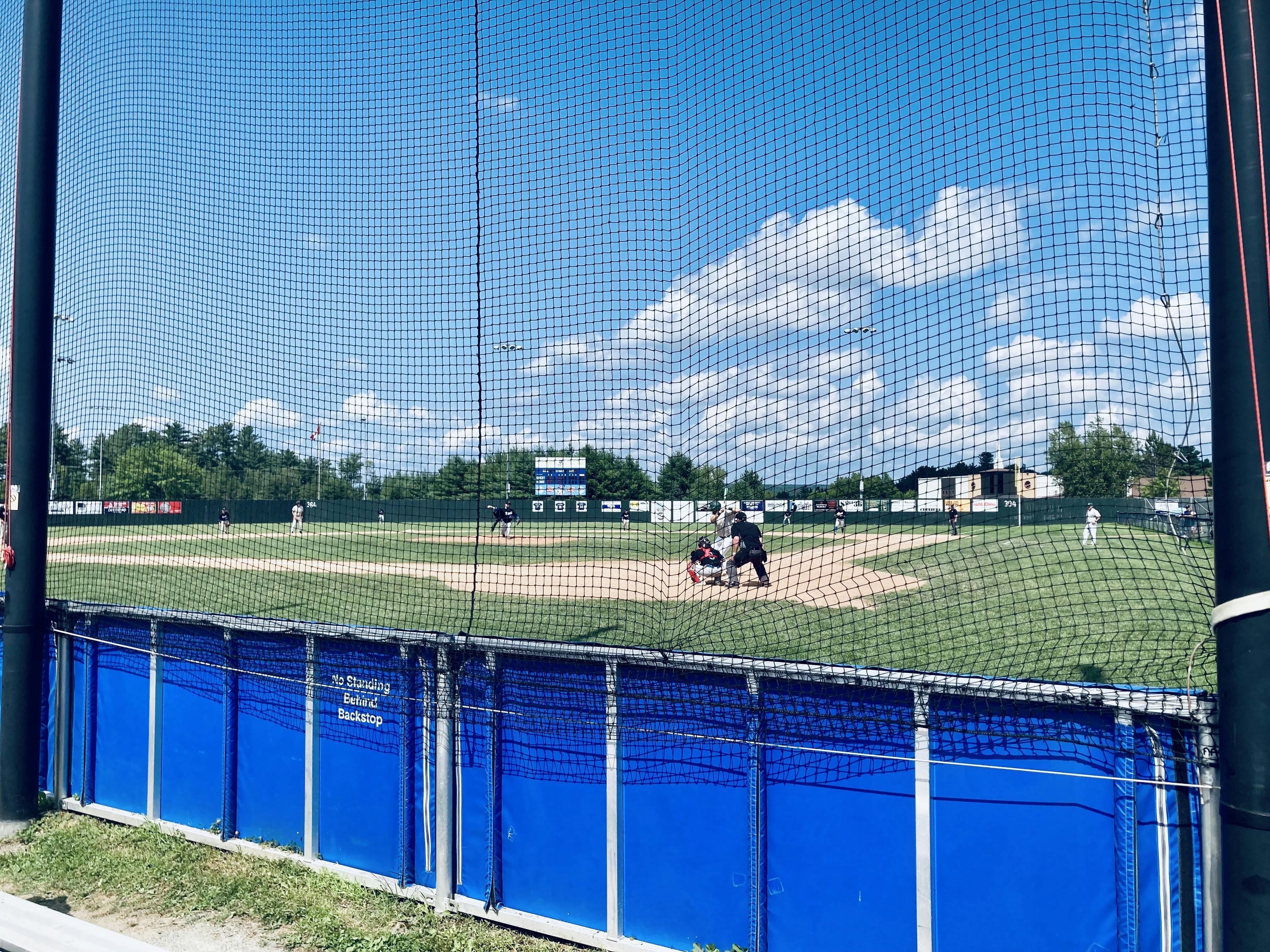 A photo from behind the plate at a baseball game, with the pitcher just about to throw the pitch.