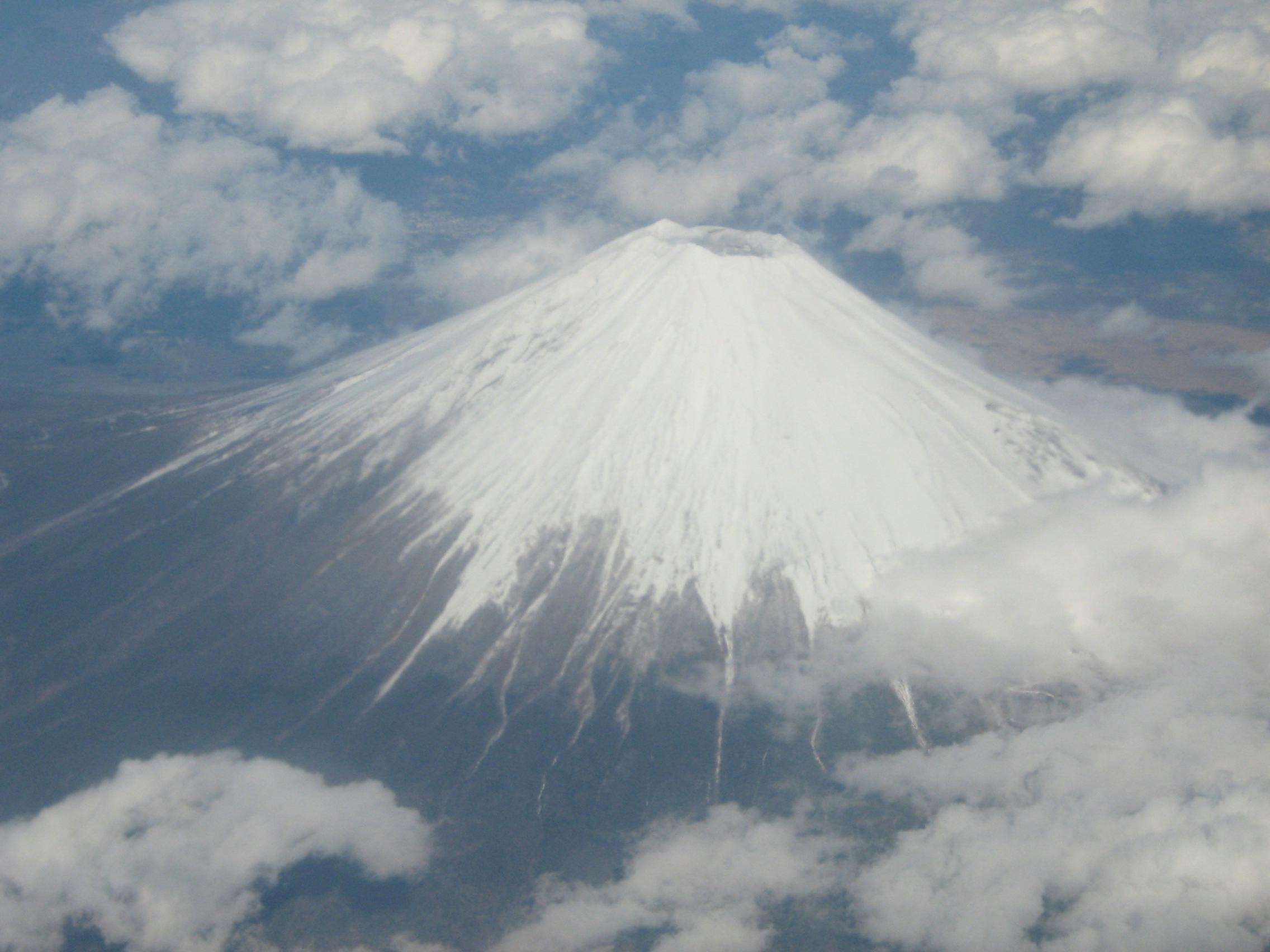 A photo of Mt. Fuji covered in snow, taken from an airplane.