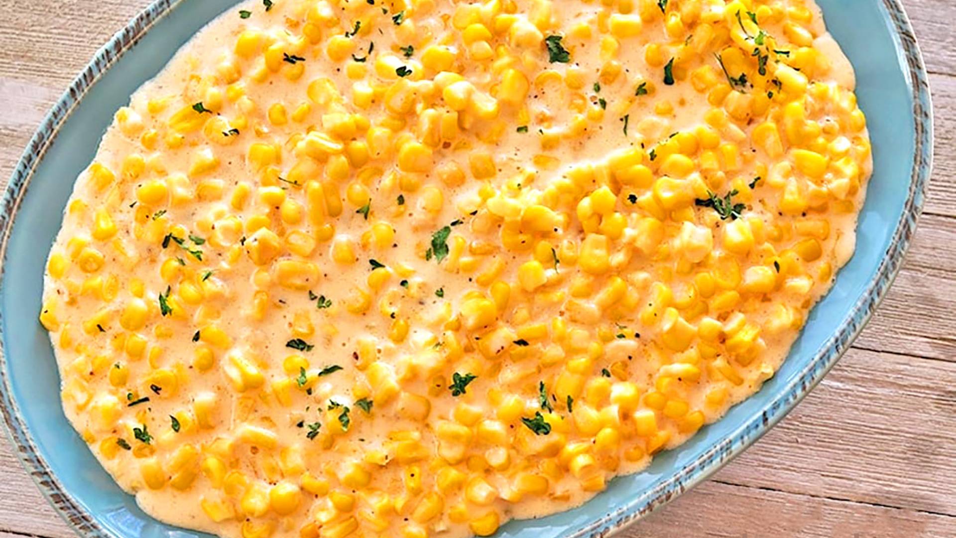 Slow Cooker Creamed Corn in a blue stonware bowl.
