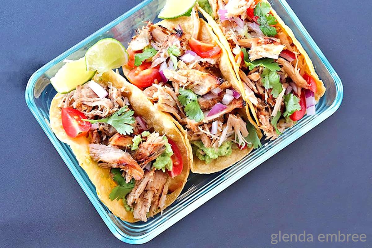 Pork Carnitas tacos in a clear glass rectangular dish.