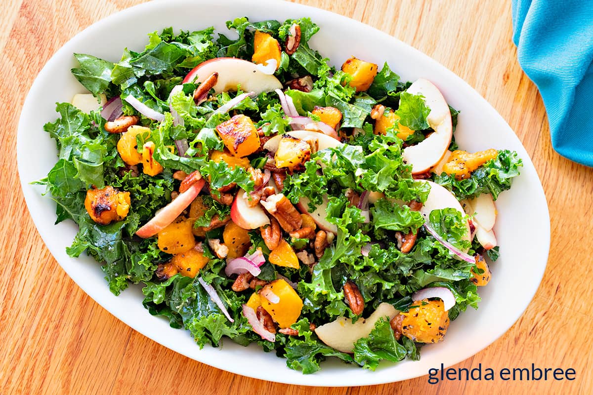 Kale Salad with Apples and Roasted Butternut Squash in a white oval serving dish.