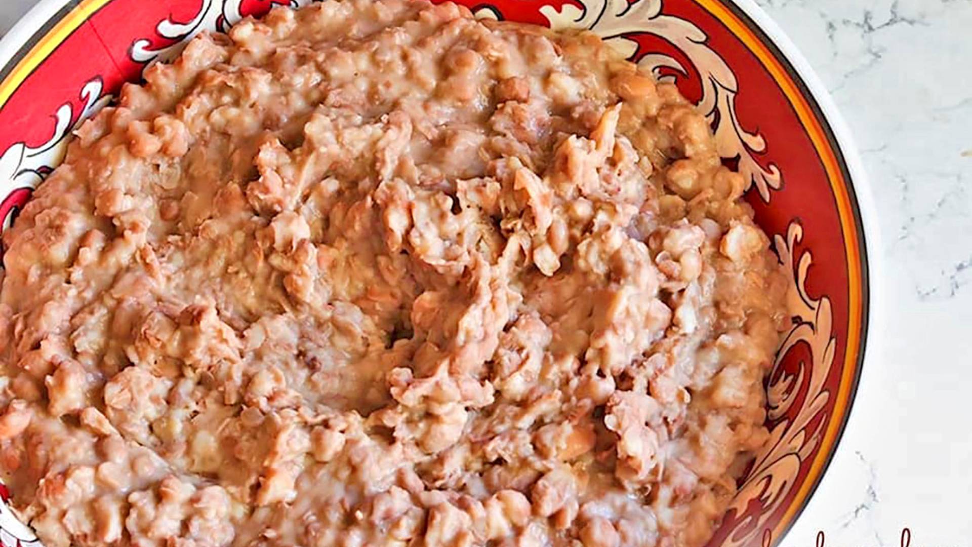 Homedmade refried beans in a serving bowl.