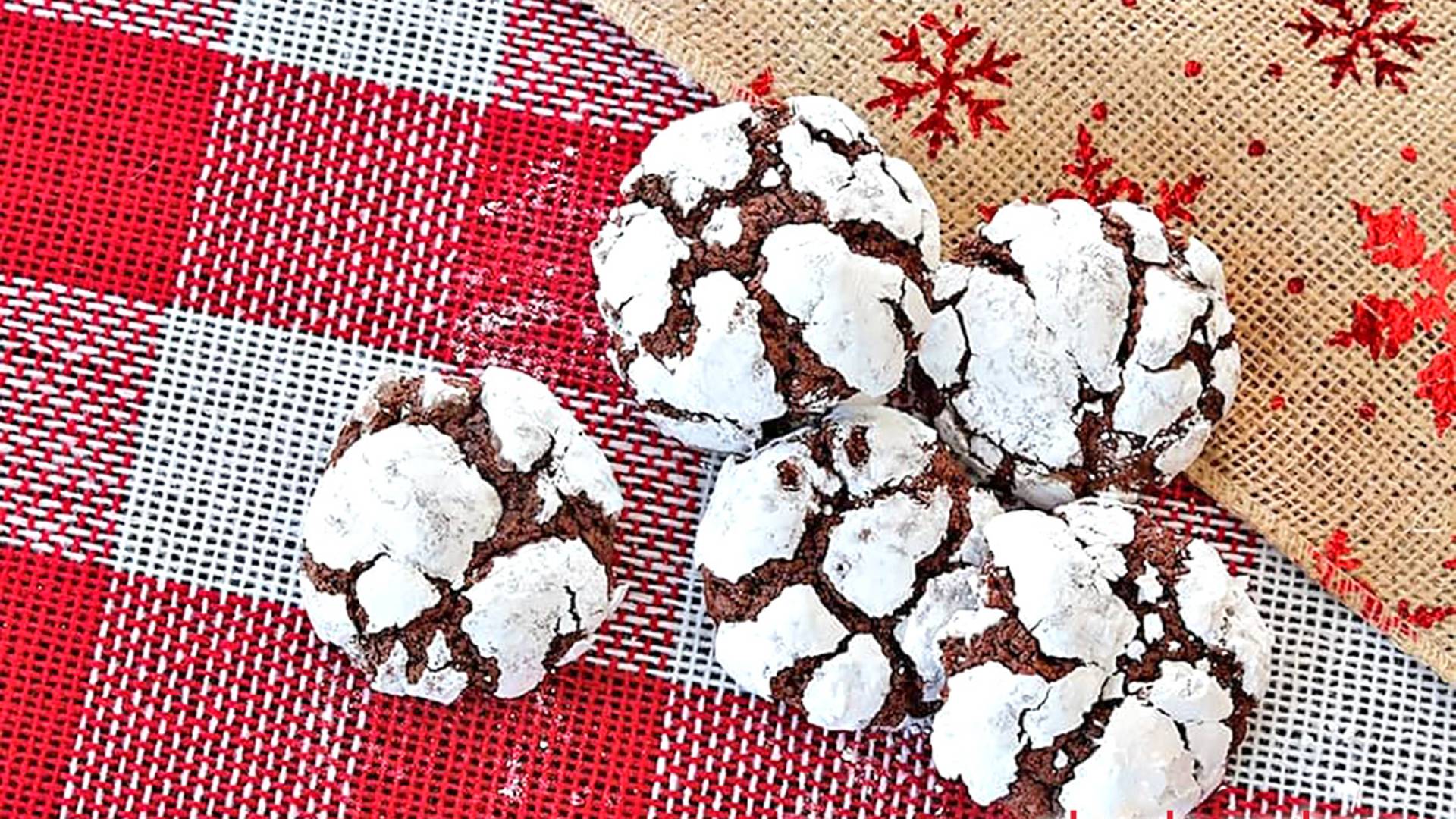 Chocolate Crinkle cookies resting on red and white holiday burlap.