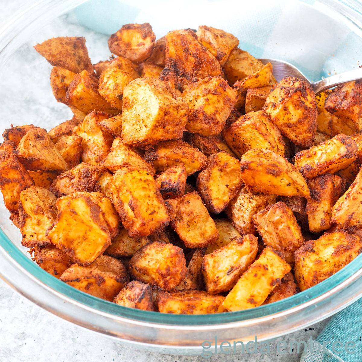 Easy Taco Potatoes (Taco Fries) in a clear glass bowl on a concrete countertop.