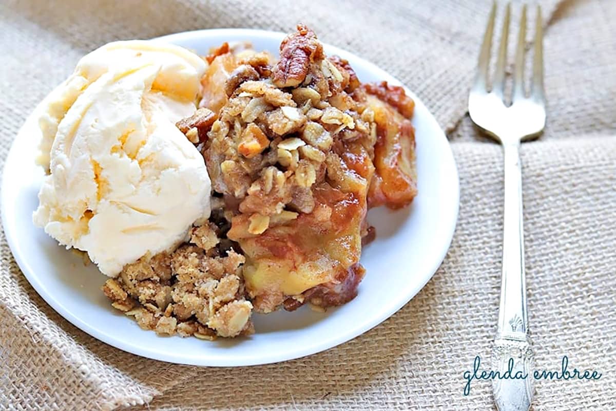 Apple Crisp on a white plate with vanilla ice cream.
