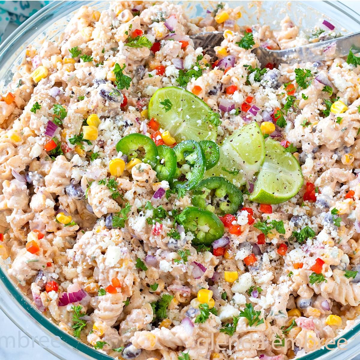 Mexican Street Corn Pasta Salad in a clear glass mixing bowl.