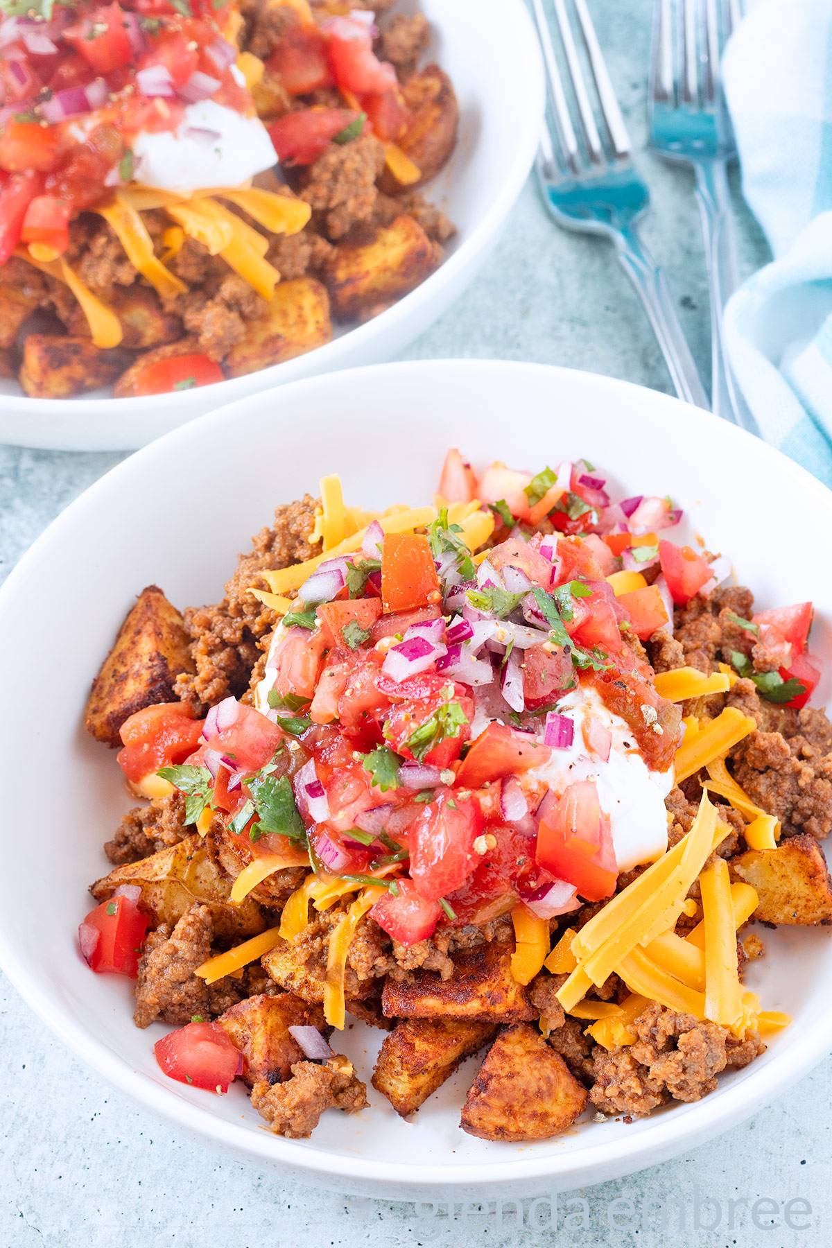 Easy taco bowls in white serving bowls on a concrete countertop.